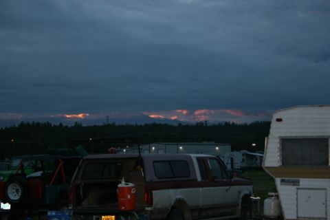1990 Chevrolet Suburban - A pickup truck and a trailer are parked outdoors as the sun sets behind distant mountains.