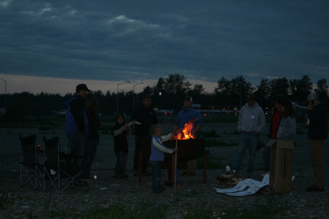 People gathered around a fire pit at dusk