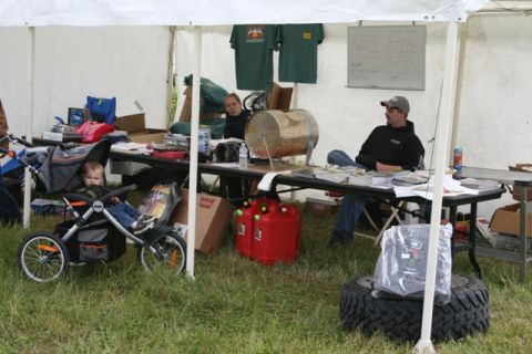 1990 Chevrolet Suburban - An outdoor event tent is set up with people attending to tables and a baby in a stroller.