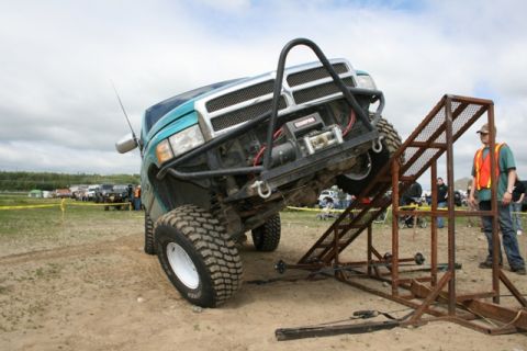 1990 Chevrolet Suburban - Modified Dodge Ram truck navigates an obstacle course during an off-road event.