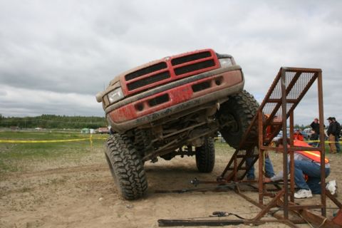 1990 Chevrolet Suburban - A modified Dodge Ram truck is positioned on an off-road course, with its front wheels elevated.