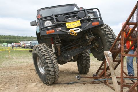 1990 Chevrolet Suburban - Off-road vehicle navigates a challenging obstacle course during an event.