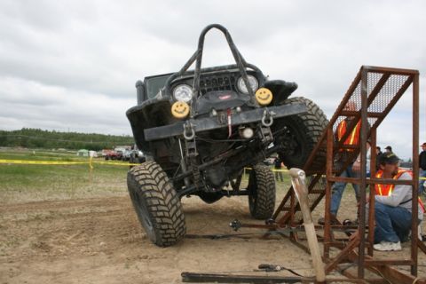 1990 Chevrolet Suburban - A heavily modified Jeep Wrangler is positioned on an off-road obstacle course with people nearby.