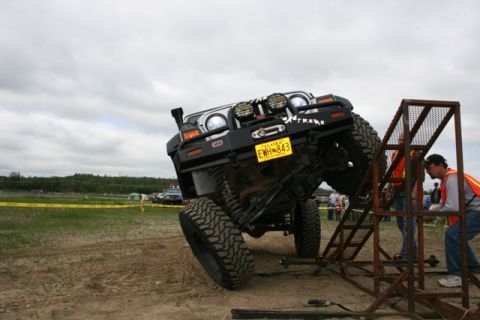 1990 Chevrolet Suburban - Modified Jeep Wrangler attempts to climb a metal ramp during an off-road event.
