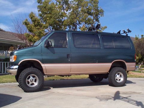 2001 Ford E150 - Lifted 2001 Ford E150 van shown from the side, equipped with a roof rack.