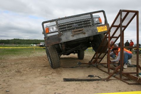 1990 Chevrolet Suburban - A 1990 Ford F-Series truck is positioned on an obstacle course, with a person in an orange vest working on equipment nearby.