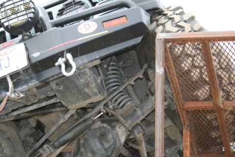 1990 Chevrolet Suburban - The underside of a modified off-road vehicle, likely a Chevrolet Suburban, is shown tilted at an angle. Visible components include a large…