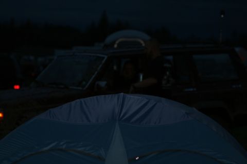 1990 Chevrolet Suburban - A dark, low-light photo shows the front of a dark-colored SUV, possibly a 1990 Chevrolet Suburban, with a person visible in the driver's se…