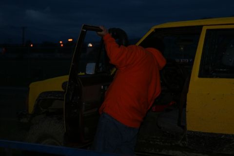 1990 Chevrolet Suburban - A person in an orange hoodie and jeans is getting into the driver's side of a yellow Jeep with the door open. The vehicle appears to be off…