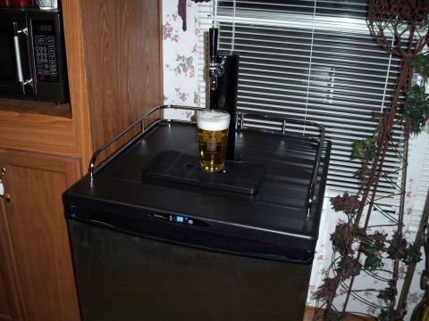 1996 Ford Bronco - A close-up view of a beer tap and a glass of beer on top of a small refrigerator. The refrigerator has a digital display showing "39".