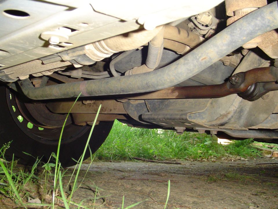 Underside of a Ford Crown Victoria showing suspension, sway bar, brake rotor, and tire.