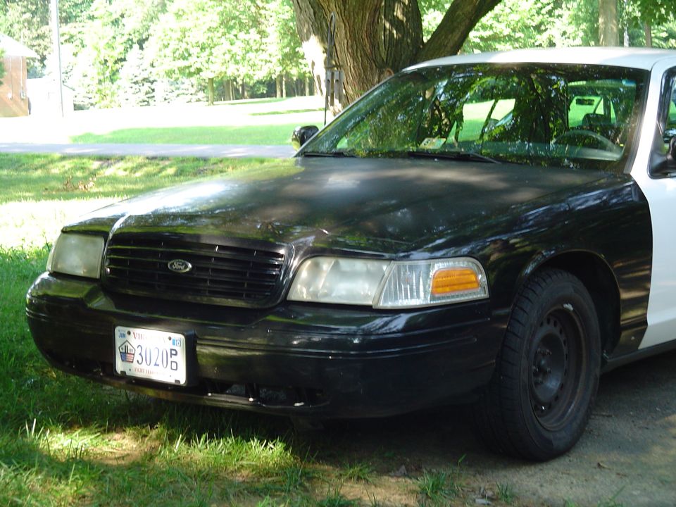 Black and white Ford Crown Victoria police car front view with license plate 3020P