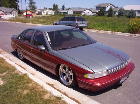 1998 Ford Crown Victoria - Front three-quarter view of a lowered two-tone Chevrolet Caprice parked on a residential street.
