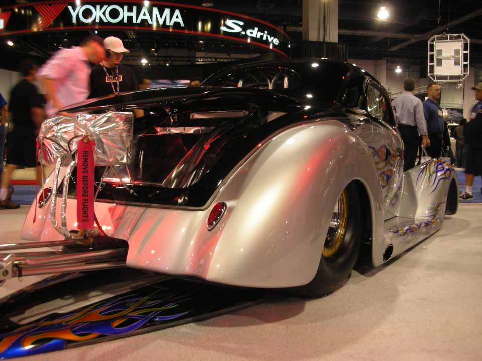 Black and silver custom hot rod with flames at a show