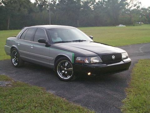 1998 Ford Crown Victoria - Front three-quarter view of a two-tone Mercury sedan on black and chrome wheels in a driveway.