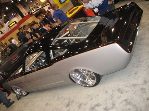 1998 Ford Crown Victoria - Photograph of a customized black and silver fastback show car on display at an indoor automotive event.