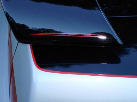 1998 Ford Crown Victoria - Close-up photograph of a black rear spoiler with red pinstripe detailing on a custom car.