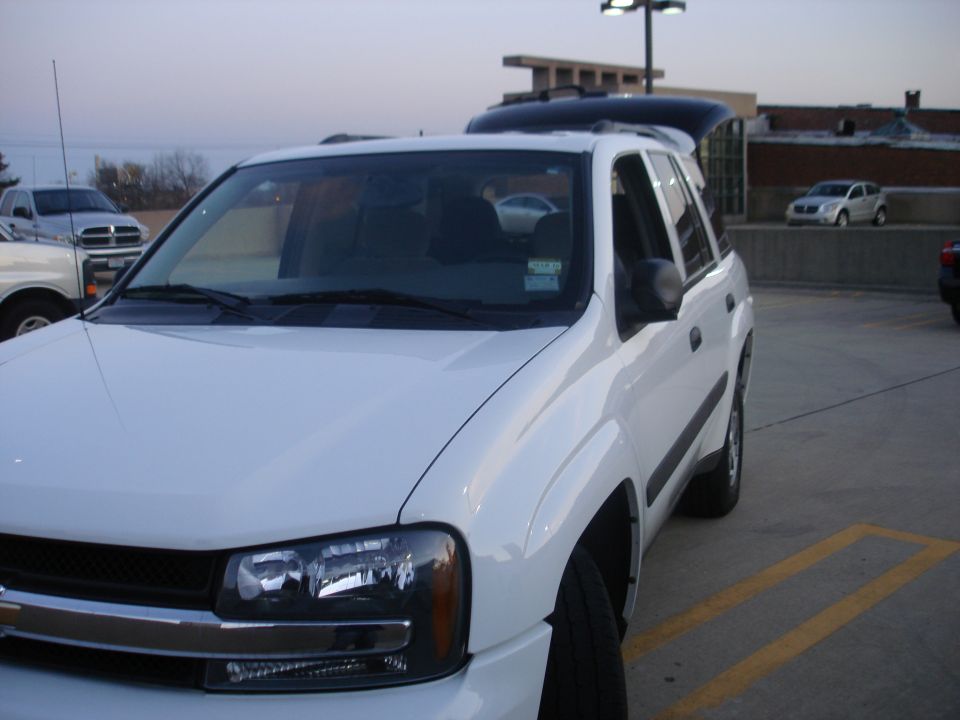 White Chevrolet TrailBlazer SUV front three-quarter view in parking lot at dusk