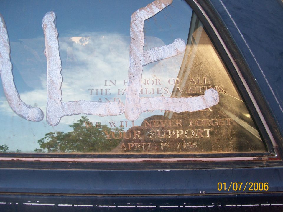 Dark vehicle window etched with April 19 1995 memorial text and white painted letters