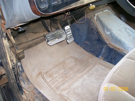 1988 Ford Bronco - Interior view of a vehicle's footwell, showing pedals and floor mat.