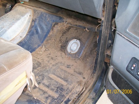 1988 Ford Bronco - The interior floor of a vehicle is covered in mud, obscuring any specific year identification.