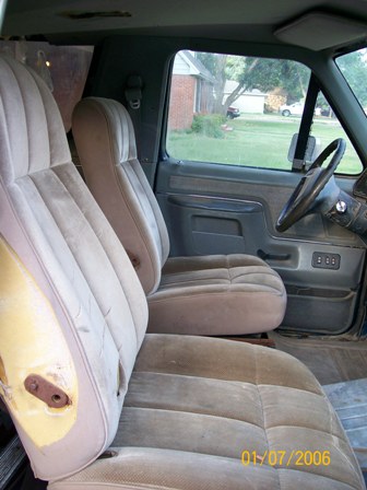 1988 Ford Bronco - Front interior of a 1988 Ford Bronco, cloth seats and a view of the dashboard and steering wheel.