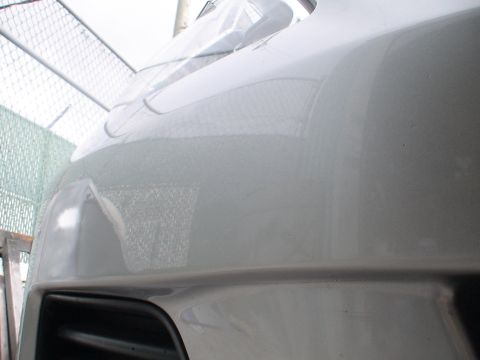 1993 Ford C-350 (Centurion Conversions) - Close-up view of a white vehicle's front bumper and grille.