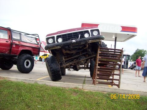 1978 Ford Bronco - Modified 1978 Ford Bronco attempts to climb a metal structure at a gas station.