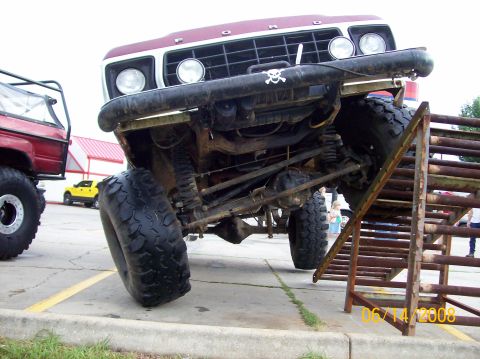 1978 Ford Bronco - A maroon 1978 Ford Bronco is shown from the front, angled up a metal ramp with its front tire off the ground.