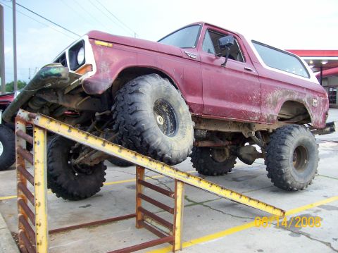1978 Ford Bronco - This lifted 1978 Ford Bronco is positioned on a ramp, its large off-road tires and modified suspension.