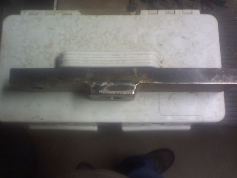 1993 Ford Bronco - A metal part with a welded bracket is placed on a white plastic case.