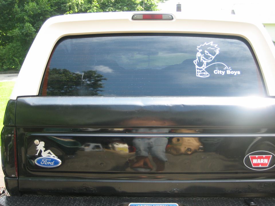 Rear of a Ford Bronco with a Ford logo sticker and a 'City Boys' sticker on the window