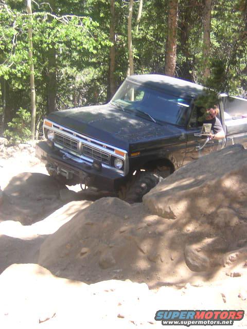 1995 Ford Bronco - This truck is navigating a challenging rocky path through a forest.