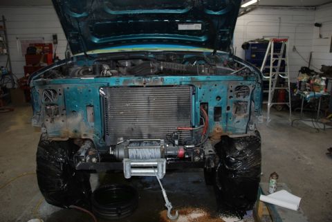 1996 Ford Bronco - The front end of a 1996 Ford Bronco is shown with the hood open, revealing the engine bay, radiator, and a winch installed.