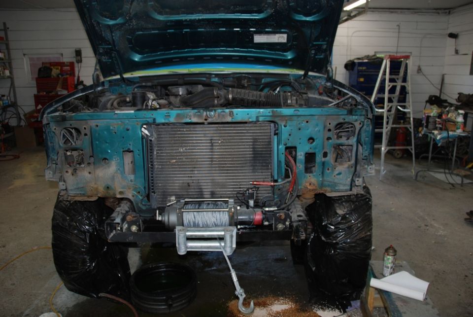 Teal 1996 Ford Bronco front end with hood open, radiator, and winch
