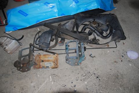 1996 Ford Bronco - Various vehicle components, possibly from a Ford Bronco, are scattered on the ground.