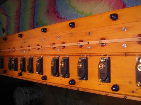 1995 Ford Bronco - A close-up view of a custom-built electrical panel with numerous switches and visible wiring, mounted on a wooden board.