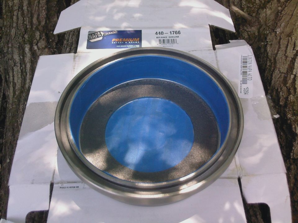 New NAPA Premium brake drum 440-1766 with blue coating displayed on its open box outdoors