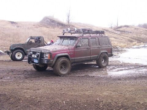 1972 Pontiac Grand Prix - Two off-road vehicles are stuck in the mud on a hill.