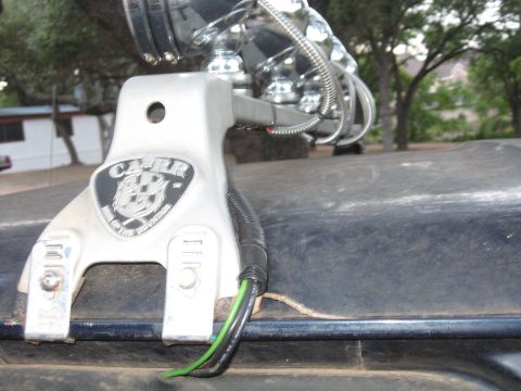 1990 Ford Bronco - A close-up shot focuses on the mounting bracket for KC lights, showing the brand name and wiring details offt-road designation.