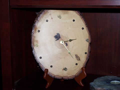 1995 Ford C-350 (Centurion Conversions) - A rustic clock face made from a slice of wood, brass hands and hour markers, displayed on a wooden stand.
