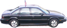 1972 Pontiac Grand Prix - A black sedan is shown from the side, with an American flag mounted on its roof.