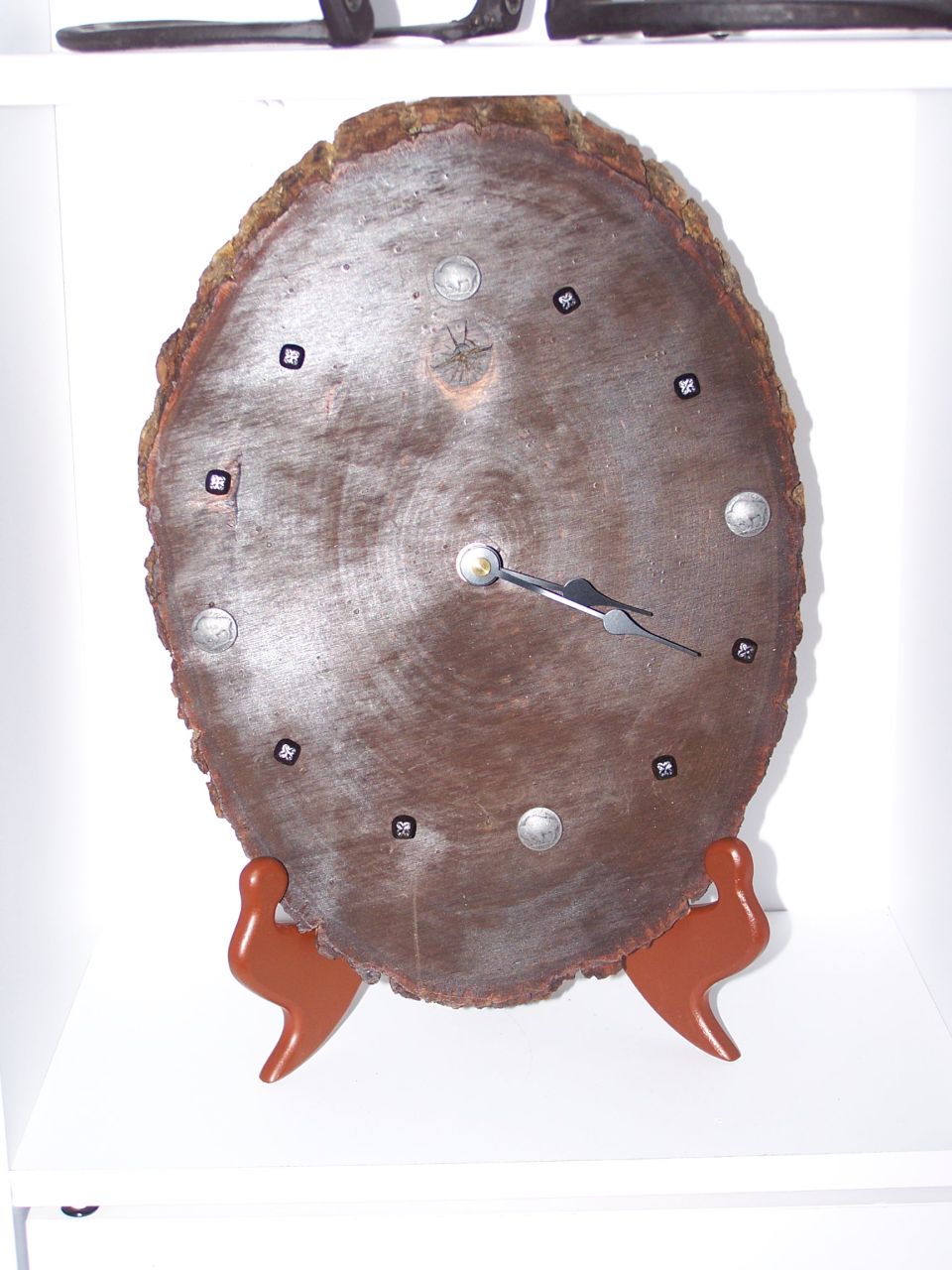 Wood slice clock with metal hour markers and clock hands, on a stand