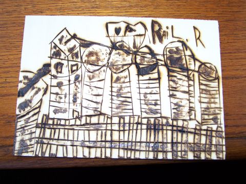 1995 Ford C-350 (Centurion Conversions) - A wood-burned drawing on paper shows a stylized cityscape with a fence in the foreground and text "Rail R."