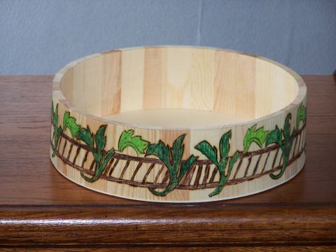 1995 Ford C-350 (Centurion Conversions) - Wooden bowl with a decorative border green leaves and a fence pattern.