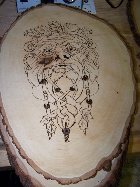 1995 Ford C-350 (Centurion Conversions) - A detailed wood burning features a green man face with intricate Celtic knotwork and foliage.