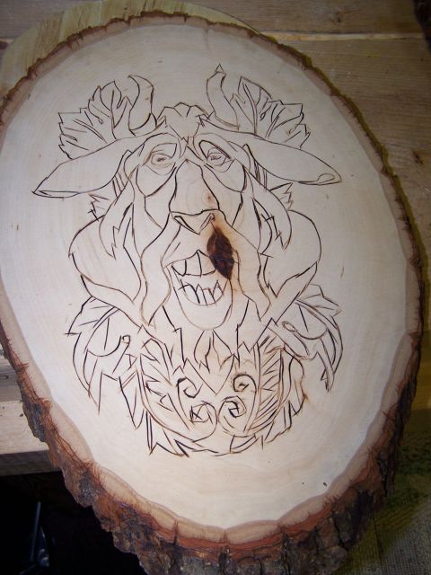1995 Ford C-350 (Centurion Conversions) - A wood carving of a face with a wide grin and leafy accents is etched onto a circular wood slice.