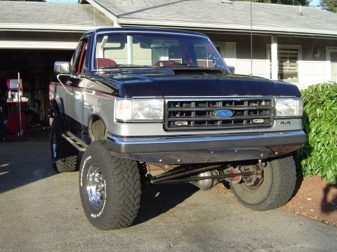 1989 Ford Bronco - This lifted Ford pickup truck features a two-tone paint scheme and aggressive off-road tires.