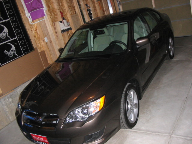 Dark brown sedan parked in a garage, high front three-quarter view