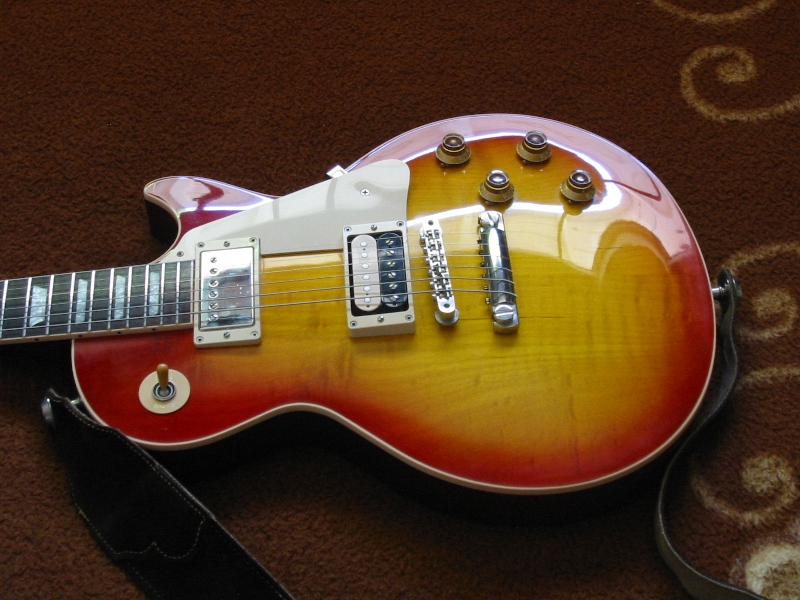 Sunburst finish electric guitar with chrome hardware and a black strap